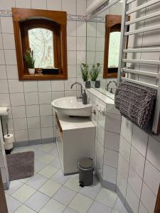 a white bathroom with a sink and a mirror at Jagdstube in Prezelle