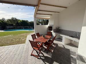 a table and chairs on a patio with a pool at RElaxed city living in Port Elizabeth