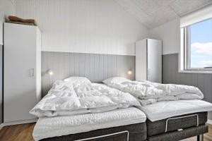 a bedroom with a bed with white sheets and a window at LF12003-Spottrup-Molleparken-32 in Spottrup