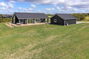 a black house in a field with a large yard at LF12003-Spottrup-Molleparken-32 in Spottrup