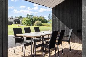 a wooden table and chairs on a wooden deck at LF12003-Spottrup-Molleparken-32 in Spottrup +20 photos