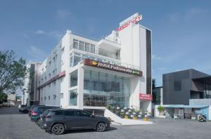 a building with cars parked in front of it at Manjhi Stay in Tiruchirappalli