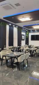 a dining room with tables and chairs and a flat screen tv at Апарт-отель Homeland in Gonio