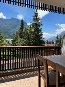 a wooden table on a balcony with a view of mountains at Tra Neve e Lago Mountain Apartment in Sella Nevea +12 photos