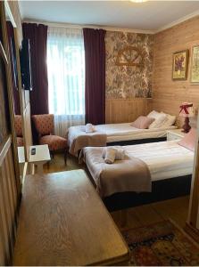 a hotel room with two beds and a television at Hotell Tussilago i Essunga in Nossebro +43 photos
