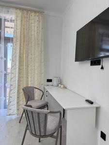 a room with two chairs and a desk and a television at Өркүндө in Chon-Sary-Oy