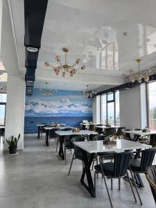 a dining room with tables and chairs and a chandelier at Өркүндө in Chon-Sary-Oy