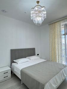 a bedroom with a large bed and a chandelier at Өркүндө in Chon-Sary-Oy