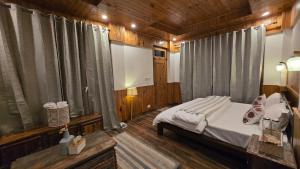 a bedroom with a bed in a wooden room at Almost Home in Shangarh