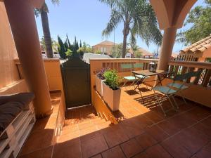 a patio with a table and chairs on a balcony at Brisa de la Barrosa in Novo Sancti Petri