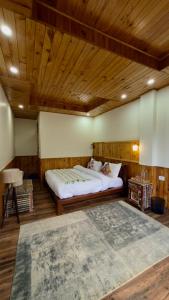 a bedroom with a large bed and a wooden ceiling at Almost Home in Shangarh