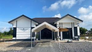 a house with an open garage with an umbrella at Homestay ZASS in Arau