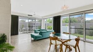a living room with a couch and a table and chairs at Luxury Townhouse Maroochydore in Maroochydore