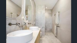 a bathroom with a white sink and a mirror at Luxury Townhouse Maroochydore in Maroochydore +13 photos