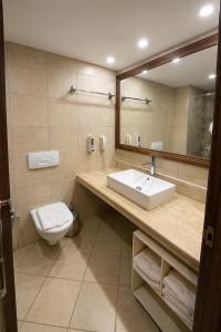 ein Badezimmer mit Waschbecken, Toilette und Spiegel in der Unterkunft Okaliptus Otel in Bitez + 33 Fotos