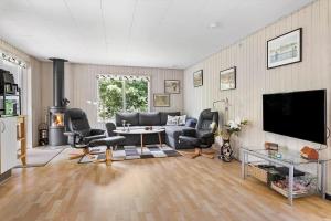 a living room with a couch and chairs and a tv at LF16084-Farso-Kjeldhoj-84 in Farsø