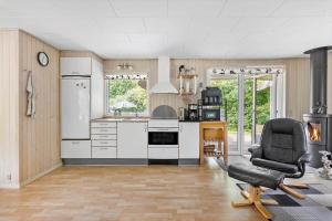 a kitchen with a refrigerator and a chair in a room at LF16084-Farso-Kjeldhoj-84 in Farsø