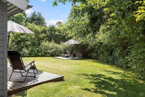 a patio with two chairs and an umbrella in a yard at LF16084-Farso-Kjeldhoj-84 in Farsø