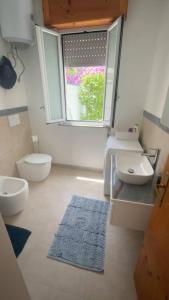 a bathroom with two toilets and a sink and a window at Villa Malsine in Marzamemi +30 photos