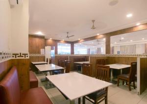 a dining room with tables and chairs in a restaurant at Manjhi Stay in Tiruchirappalli