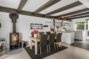 a kitchen and dining room with a wood stove at LF15103-Farso-Rorsangervej-3 in Farsø +12 photos