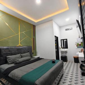 a bedroom with a large bed with a green wall at Wisma 11 Oktober in Palangkaraya