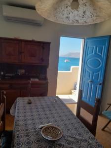 a dining room with a table and a door to the ocean at Casa vacanze levanzo in Levanzo