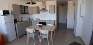 a kitchen with a table and chairs and a refrigerator at Gîte Le Fenil in Allondrelle-la-Malmaison +4 photos