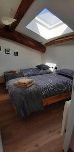 a bedroom with two beds and a skylight at Gîte Le Fenil in Allondrelle-la-Malmaison