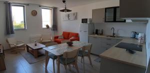 a kitchen and living room with a table and chairs at Gîte Le Fenil in Allondrelle-la-Malmaison