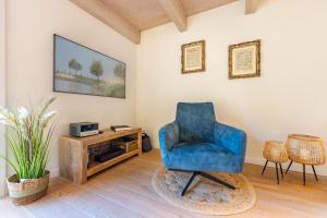 a living room with a blue chair and a tv at Ferienhaus Hyggehüs in Risum-Lindholm