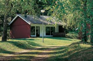 a red building with a red garage at Degeberga Stugby in Degeberga