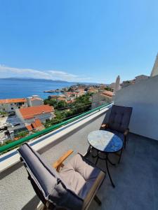 a balcony with two chairs and a table and the ocean at Apartments Toni Two in Igrane