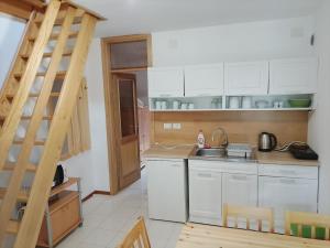a kitchen with white cabinets and a staircase in it at Soča Trails Apartment #6 in Log Čezsoški