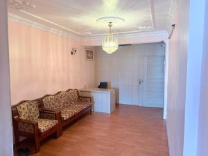 a waiting room with two chairs and a desk and a chandelier at Lux Apartment in Kathmandu