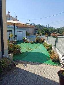 a yard with a green lawn with a hose at Os Pimentinhas in Ribeiro