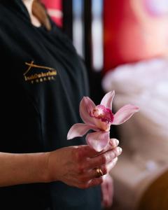a woman holding a pink flower in her hand at Buddha-Bar Hotel Prague in Prague