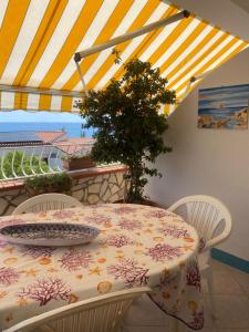 a table and chairs with a table and an umbrella at Sole Mare da Tina in Cittadella del Capo