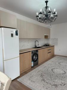 a kitchen with a white refrigerator and a dishwasher at Парус in Cholpon-Ata
