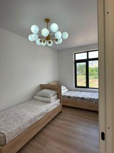 a bedroom with two beds and a chandelier at Парус in Cholpon-Ata