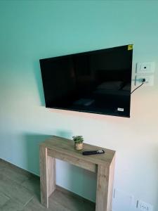 a flat screen tv on a wall with a wooden table at Stazione 21 - Pescara Loft in Pescara