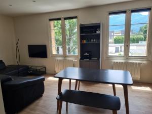 a living room with a table and a couch at Chambre proche du Polygone scientifique - EdF - Schneider - GEM in Saint-Martin-le-Vinoux
