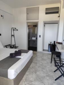 ein Schlafzimmer mit einem Bett, einem Schreibtisch und einem Stuhl in der Unterkunft Petteo Serifos in Livadakia