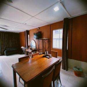 a dining room with a wooden table and chairs at TC Maya Abaya Hotel in Kuantan