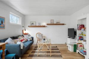 a living room with a blue couch and a table at LF18116-Veslos-Agerovej-6 in Amtoft