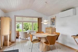 a kitchen and dining room with a table and chairs at FJ1200-Jaegerspris-Planetvej-8 in Jægerspris