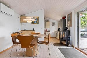 a kitchen and dining room with a table and chairs at FJ1200-Jaegerspris-Planetvej-8 in Jægerspris +13 photos