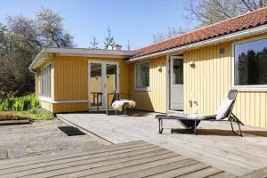 a house with a chair on a wooden deck at 13374-1-Vig-Thorsvej-4 in Vig