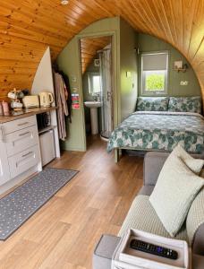 a bedroom with a bed and a couch in a room at Knockmany View Glamping in Augher