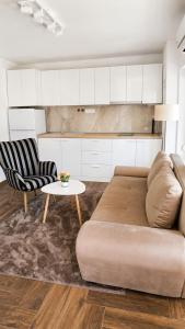 a living room with a couch and two chairs and a table at Danube Panorama House - River View, Jacuzzi & Nature in Čelarevo